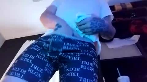 Media: A video of a person wearing a white t-shirt and blue pajama pants with the word \"TRUMP\" printed repeatedly. The person is bending over, hands on their knees, in a dimly lit room.