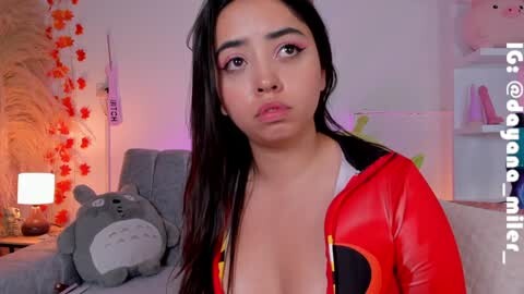 Media: A video of a young Asian woman with long black hair and medium-sized breasts, wearing a red, shiny, cropped jacket, posing indoors with plush toys and floral decor.