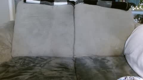 Media: Video of a gray couch with black-and-white checkered pillows and a white blanket, partially submerged in water, indicating flooding.
