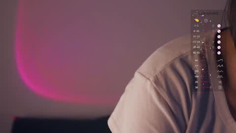 Media: Video of a person's shoulder in a beige shirt, with a digital overlay of a smartphone showing various app icons and notifications. The background features a blurred pink and purple gradient.