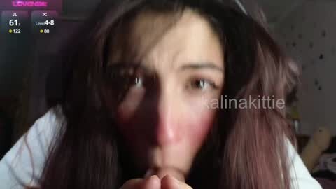 Media: Video of a young Asian woman with long, dark hair, flushed cheeks, and a worried expression, leaning forward, fingers interlocked. The background is dimly lit and indistinct, with a watermark \"alinaakittie\" overlaid.
