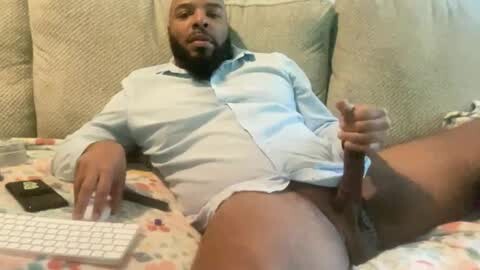 Media: Video of a Black man with a beard, wearing a blue shirt, masturbating on a floral-patterned couch. He's holding a smartphone and a white keyboard.