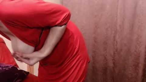 Media: A video of a fair-skinned woman with a full bust, wearing a tight, red satin dress, bending over in a bathroom with beige wallpaper and a purple towel.