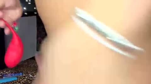 Media: Video of a woman's bare arm with white cream streaks and a red makeup sponge, set against a leopard-print background.