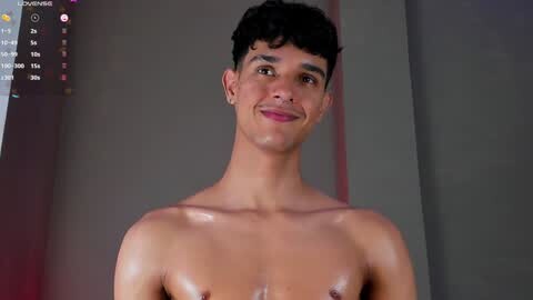Media: Video of a young, shirtless, fit Latino man with dark hair and olive skin, smiling slightly, in a dimly-lit room.