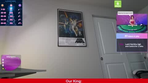 Media: A video showing a white wall with a Star Wars poster, a green screen, and a red banner reading \"Our King.\