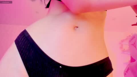 Media: Video of a pale-skinned woman's torso in black lingerie, illuminated by pink lighting, highlighting her small breasts and smooth skin, with a hint of a navel piercing.