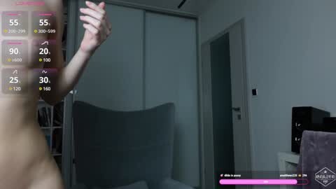Media: A video of a nude person taking a selfie in a modern bedroom with a grey sofa and wardrobe. The image includes a virtual reality overlay with health and stamina indicators.