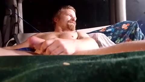 Media: Video of a naked man with a beard and light skin lying on a green boat, holding his erect penis, surrounded by dark, blurry background.