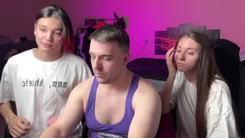 Media: Video of three young people in a casual setting; two women and one man with short hair, wearing casual clothing.
