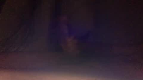 Media: A dimly-lit video shows a blurred figure in a dark room, possibly a child, wearing a purple outfit, standing near a wall. The background is indistinct, adding to the mysterious atmosphere.