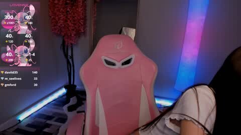 Media: Video of a pink, reclining gaming chair with a cat-like face, featuring a live stream on a monitor with pink and purple background.