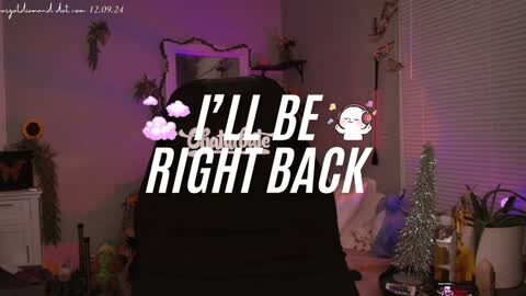 Media: A video of a dimly lit bedroom with a black-haired person wearing a black hoodie, text overlaying \"I'll Be Right Back.\" Decorations include a sunflower, a small Christmas tree, and a plant.
