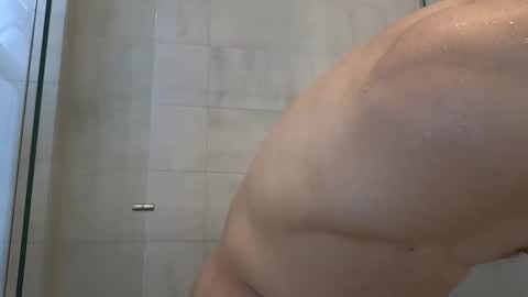 Media: Video of a bare, muscular, light-skinned man's upper body, taken in a shower with tiled walls and a metallic handle.