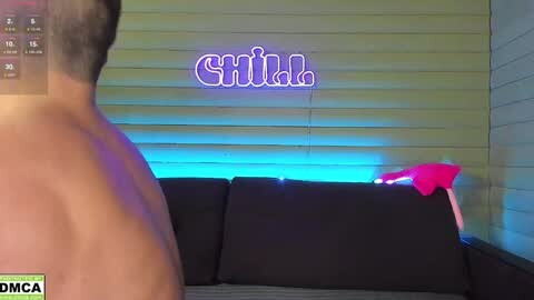 Media: Video of a man's muscular back with a neon sign \"Gina\" glowing in the background. A red cloth hangs over a black sofa.