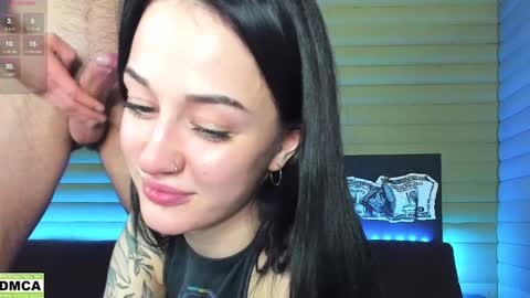 Media: A video shows a young, fair-skinned woman with long black hair and tattoos, smiling while being penetrated by a man's erect penis.