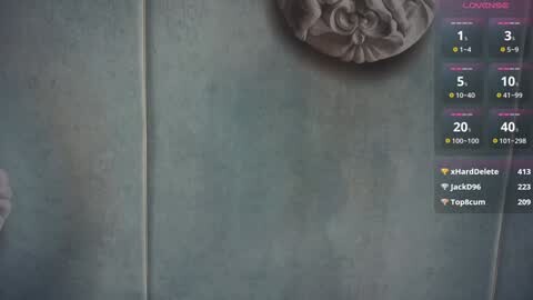 Video of a textured, metallic, teal wall with a decorative, floral, stone plaque above. A digital overlay on the right displays user statistics in a gaming context, with icons and data in pink, yellow, and white.