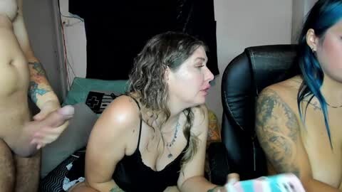 Media: A video showing a tattooed woman in black lingerie, performing oral sex on a naked man, while another woman with blue hair watches.