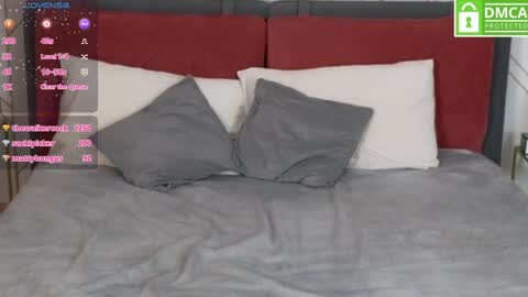 Media: A video of a neatly made bed with gray pillows on a red and white headboard. Overlayed is a live stream interface with usernames, hearts, and chat bubbles.